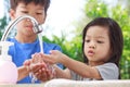 Asian boys and girls aged 4 to 8 years. Cute, bright faces are washing their hands with soap and water, washing hands with soap an
