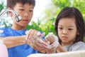 Asian boys and girls aged 4 to 8 years. Cute, bright faces are washing their hands with soap and water, washing hands with soap an