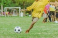 Asian boys practice kicking the ball to score goals