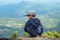 Asian boys sit on the rock see the mountains and the sky. Royalty Free Stock Photo