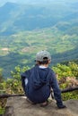 Asian boys sit on the rock see the mountains and the sky. Royalty Free Stock Photo