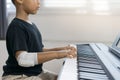 An Asian Boys At The Wounded Hands Are Playing The Piano.