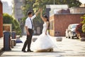 Asian bride and groom dancing in parking lot Royalty Free Stock Photo