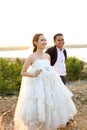 Asian bride and groom in wedding dresses against the sunset scene Royalty Free Stock Photo