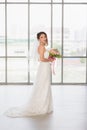 Asian bride standing and holding a bouquet Royalty Free Stock Photo