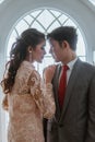 asian brides couple standing face to face and closing their eyes