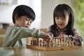 asian brother and sister playing chess at home Royalty Free Stock Photo