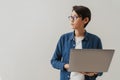 Asian brunette boy wearing eyeglasses working with laptop Royalty Free Stock Photo