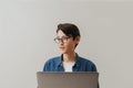 Asian brunette boy wearing eyeglasses working with laptop Royalty Free Stock Photo