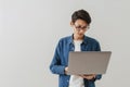 Asian brunette boy wearing eyeglasses working with laptop Royalty Free Stock Photo