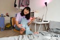 Asian brunette girl laughing while applying nail polish Royalty Free Stock Photo
