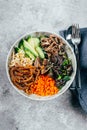 Asian buddha bowl on concrete table background. Delicious food concept