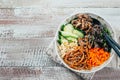 Asian buddha bowl on concrete table baclground. Grilled beef, carrot, cucumber, sprouted mung bean