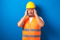 Asian builder man rubbing his head feeling fatigue