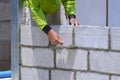 Asian builder worker building concrete block wall in house construction site