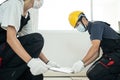 Asian builder worker people wear mask installs laminate board on floor. Construction team or Carpenter man and woman wear safety