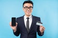 Asian buisnessman wearing suit holding smartphone and bank card