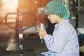Asian Burmese young woman labor worker sit and relax, playing cell phones, waiting for work shifts in food hygiene factory Royalty Free Stock Photo