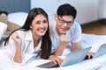 Asian business couple team working at home on the bed with laptop happy enjoy with success portrait looking camera Royalty Free Stock Photo