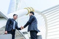 Two asian business have handshake with building and city background.