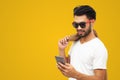Asian business man handsome man with a mustache, smiling and laughing and using smart phone on yellow background Royalty Free Stock Photo