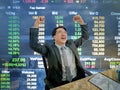 Asian business man sitting very happy becuase his stock market g Royalty Free Stock Photo