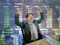 Asian business man sitting very happy becuase his stock market g Royalty Free Stock Photo