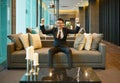 Asian Business man smiling on sofa in luxury condo Royalty Free Stock Photo