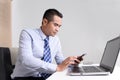 Asian business man using mobile smart phone in his office Royalty Free Stock Photo
