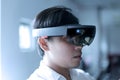 Asian business man wearing hololens glasses to experiment mixed reality.