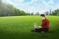 Asian business man working with laptop and sitting on the grass Royalty Free Stock Photo