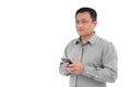 Asian business middle age man is holding smartphone or mobile phone in his hand and look out while isolated on white background Royalty Free Stock Photo