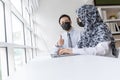 Asian business people group wearing protection face mask working and communicating at modern office desk together, brainstorm, dig Royalty Free Stock Photo