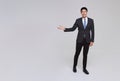 asian business people man good looking in studio. businessman in grey suit confident presenting or showing open hand palm Royalty Free Stock Photo