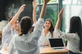 Asian business people raise their hands together