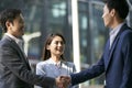 Asian business people shaking hands outdoors Royalty Free Stock Photo