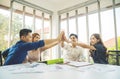 Asian Business people team with casual suit standing and giving high five at office, happy action for teamwork in the modern Royalty Free Stock Photo