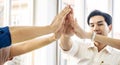 Asian Business people team with casual suit standing and giving high five at office, happy action for teamwork in the modern Royalty Free Stock Photo