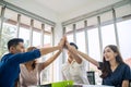 Asian Business people team with casual suit standing and giving high five at office, happy action for teamwork in the modern Royalty Free Stock Photo