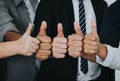 Asian business people thumbs up very good symbol together. Unity and teamwork concept