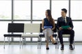 Asian business people waiting for job interview. Both of them looking at the same direction Royalty Free Stock Photo