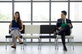 Asian business people waiting for job interview by sitting spaced apart. Concept of new normal office business during coronavirus Royalty Free Stock Photo