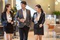 Asian business people  walking in office building. Young businessman and businesswoman talking when walking Royalty Free Stock Photo