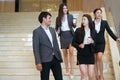 Asian business people  walking in office building. Young businessman and businesswoman talking when walking. Royalty Free Stock Photo