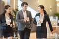 Asian business people  walking in office building. Young businessman and businesswoman talking when walking. Royalty Free Stock Photo