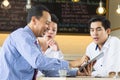 Asian business start up team meeting in cafe. Selective focus on man holging touchpad Royalty Free Stock Photo