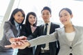 Asian business team joining hands before working