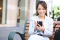 Asian Business Woman on Bench Outside Office