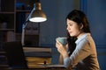 Asian business woman drink coffee refreshing working overtime la Royalty Free Stock Photo