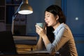 Asian business woman drink coffee refreshing working overtime la Royalty Free Stock Photo